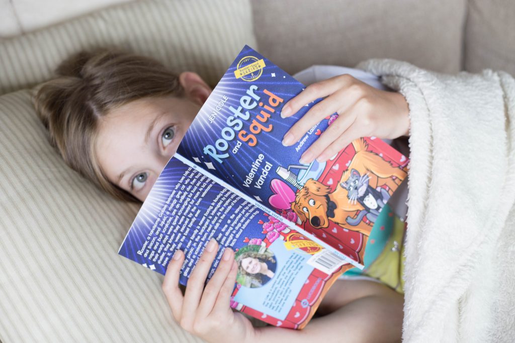 A young girl reading the Rooster and Squid Valentine Vandal book