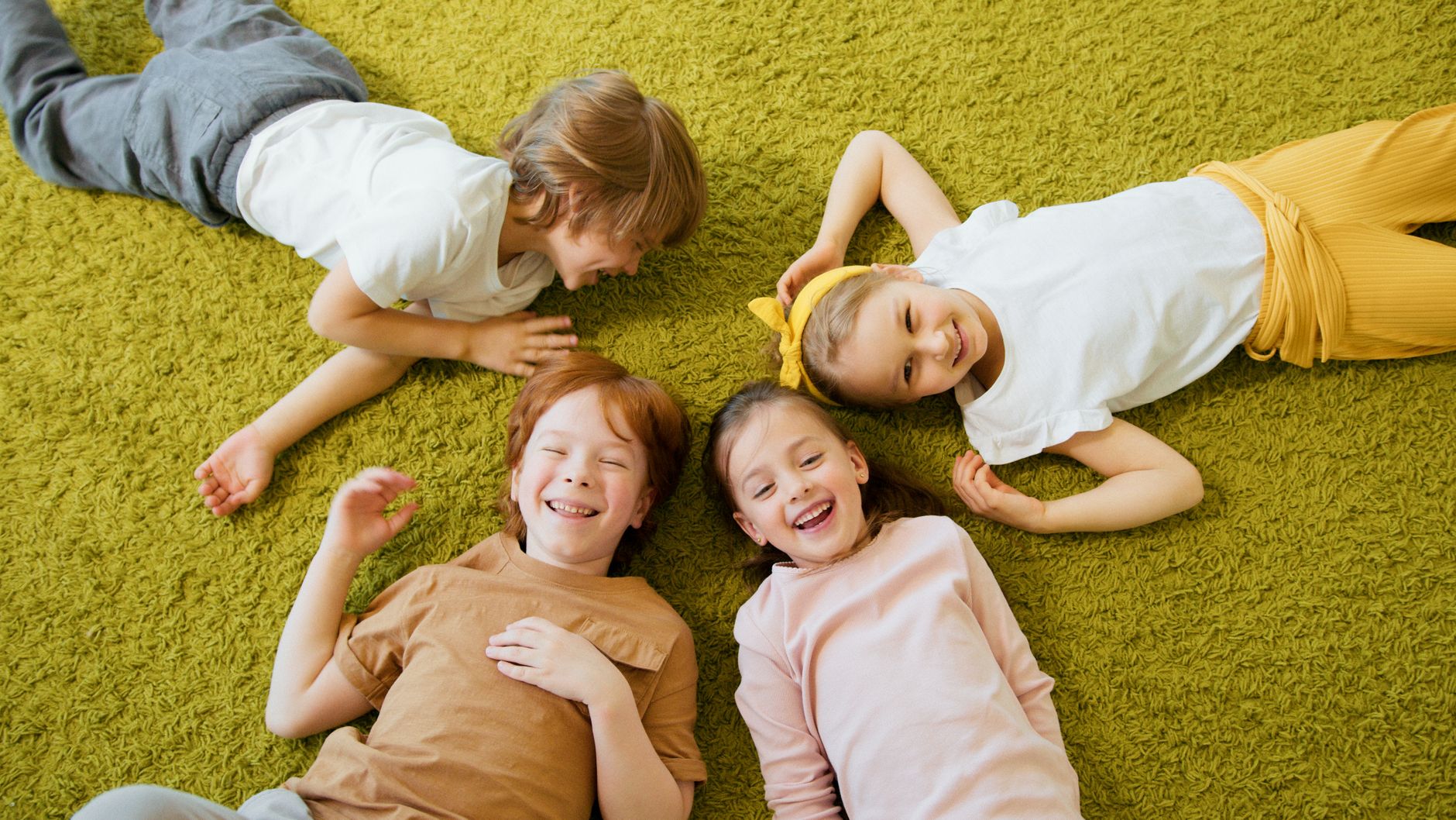 happy kids lying on textured carpet